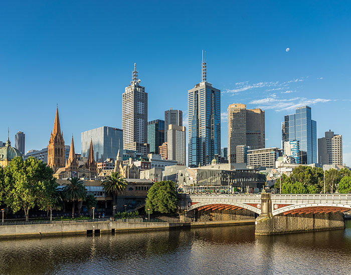 Modern city skyline with skyscrapers and historic architecture under a clear blue sky, reflecting on a calm river. Modern city skyline with skyscrapers and historic architecture under a clear blue sky, reflecting on a calm river.