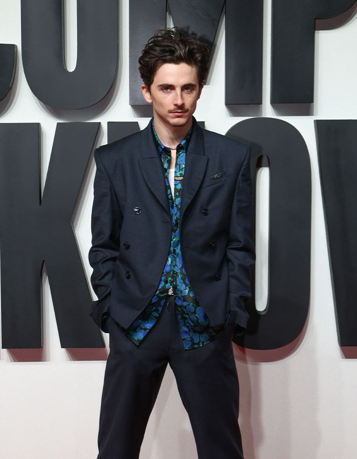 Young actor in a dark suit and floral shirt at an event, related to Oscar nominations breaking records. Young actor in a dark suit and floral shirt at an event, related to Oscar nominations breaking records.