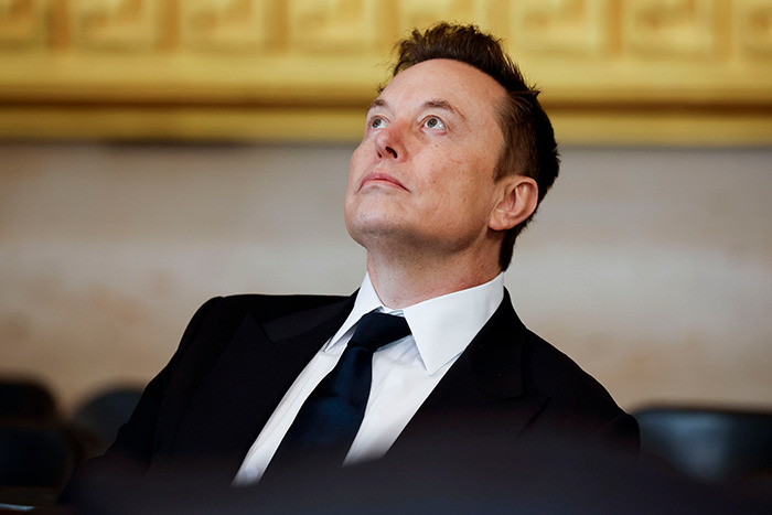 Elon Musk at presidential inauguration event, looking upwards, wearing a suit and tie. Elon Musk at presidential inauguration event, looking upwards, wearing a suit and tie.