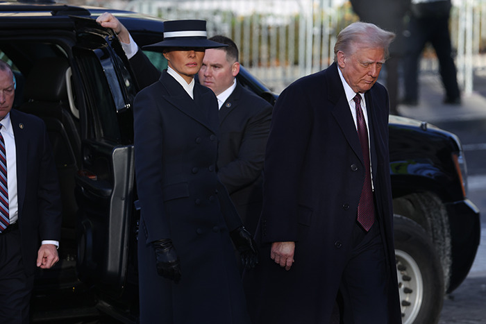 Melania Trump in a dark outfit and hat at a public event, accompanied by security, sparking humorous reactions. Melania Trump in a dark outfit and hat at a public event, accompanied by security, sparking humorous reactions.