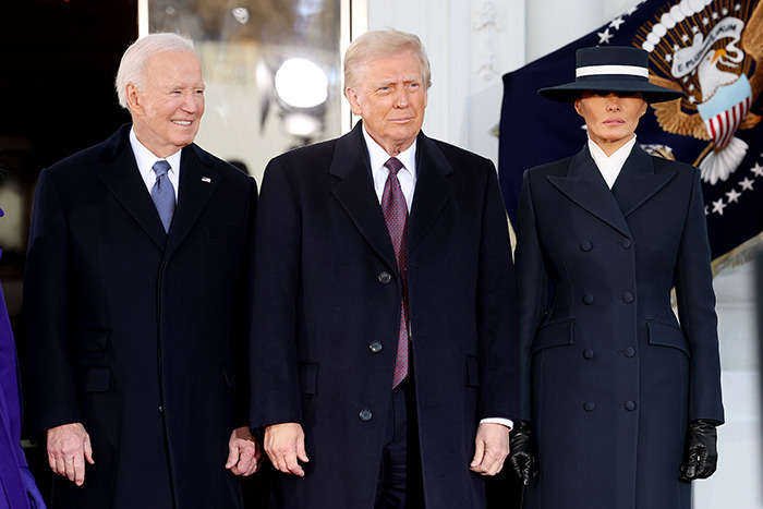 Melania Trump's outfit at the inauguration, wearing a dark coat and hat, standing with officials. Melania Trump's outfit at the inauguration, wearing a dark coat and hat, standing with officials.