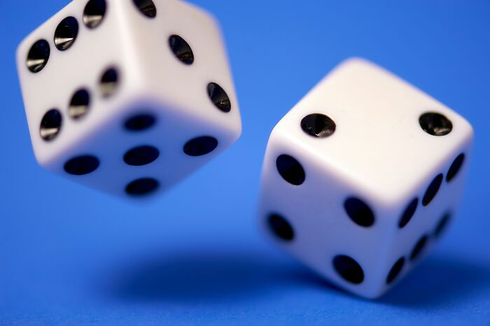 White dice with black dots on a blue background, representing classic games. White dice with black dots on a blue background, representing classic games.