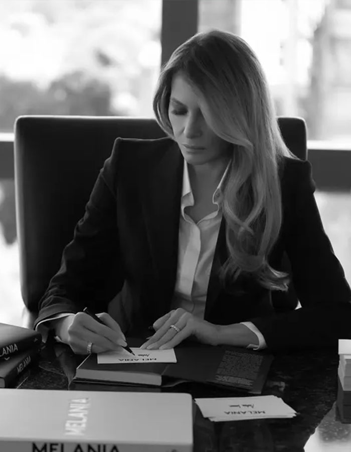 A woman in formal attire writing at a desk, surrounded by books, in a black-and-white setting, related to freelance magician. A woman in formal attire writing at a desk, surrounded by books, in a black-and-white setting, related to freelance magician.