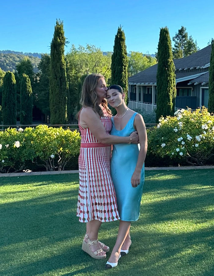 Two women embracing on a lawn, surrounded by greenery, related to Epstein Island topic discussion. Two women embracing on a lawn, surrounded by greenery, related to Epstein Island topic discussion.