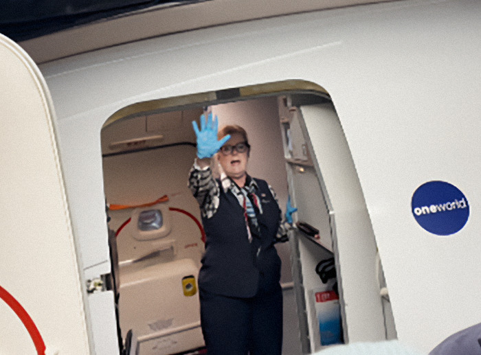 Airline staff in uniform with gloves, standing in aircraft doorway. Airline staff in uniform with gloves, standing in aircraft doorway.
