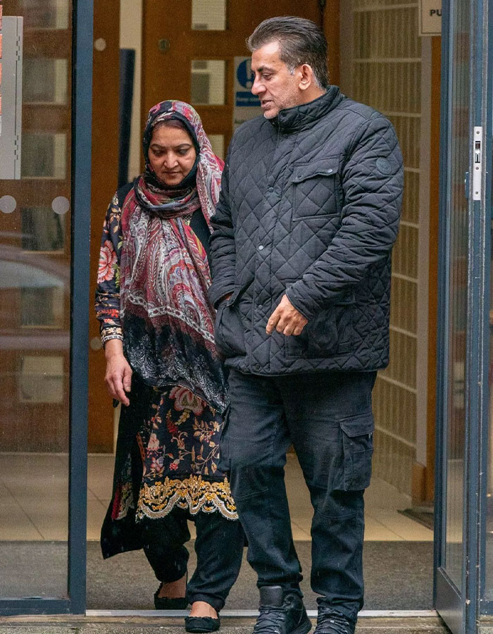 Two people exiting a building, wearing winter clothing, associated with arranged marriage case. Two people exiting a building, wearing winter clothing, associated with arranged marriage case.