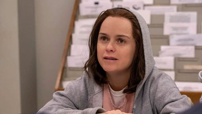 Orange Is The New Black actress in a gray hoodie, appearing thoughtful in a casual setting. Orange Is The New Black actress in a gray hoodie, appearing thoughtful in a casual setting.