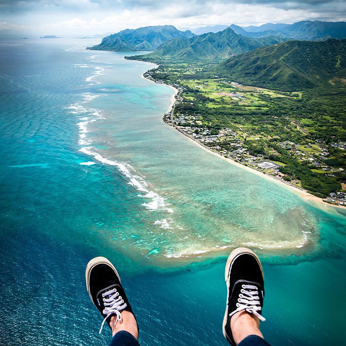 Aerial view over coastline with visible legs, resembling Tom Anderson enjoying a scenic flight. Aerial view over coastline with visible legs, resembling Tom Anderson enjoying a scenic flight.
