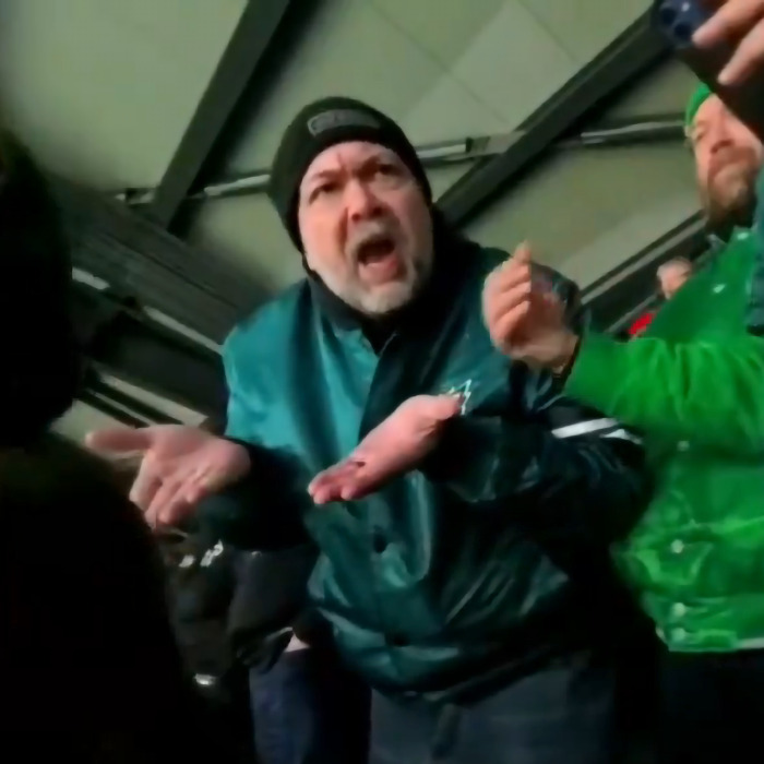 Abusive Eagles fan gesturing angrily at a stadium, wearing a green jacket and black beanie. Abusive Eagles fan gesturing angrily at a stadium, wearing a green jacket and black beanie.