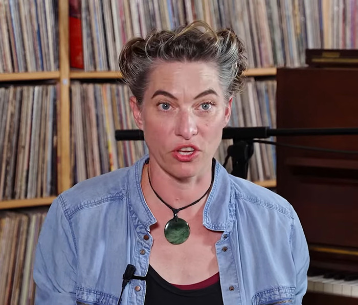 Amanda Palmer sitting in front of shelves filled with records, speaking, and wearing a blue denim shirt and necklace. Amanda Palmer sitting in front of shelves filled with records, speaking, and wearing a blue denim shirt and necklace.