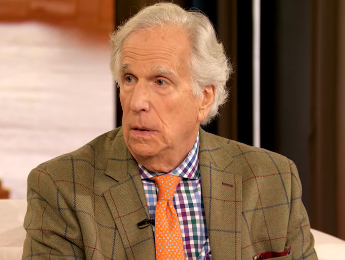 Henry Winkler in a checkered shirt and plaid jacket discussing LA wildfires theory. Henry Winkler in a checkered shirt and plaid jacket discussing LA wildfires theory.