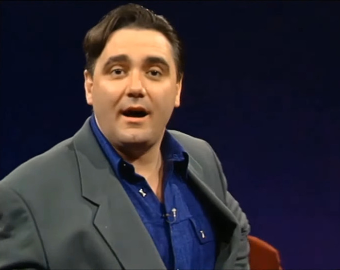 Whose Line Is It Anyway? star in a suit, speaking on stage, remembered fondly by fans. Whose Line Is It Anyway? star in a suit, speaking on stage, remembered fondly by fans.