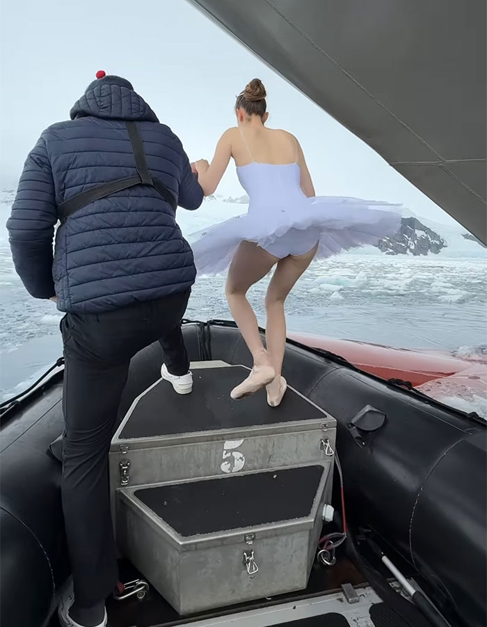 Ballerina dancing on a ship's bow in Antarctica, illustrating career ending danger in icy waters. Ballerina dancing on a ship's bow in Antarctica, illustrating career ending danger in icy waters.