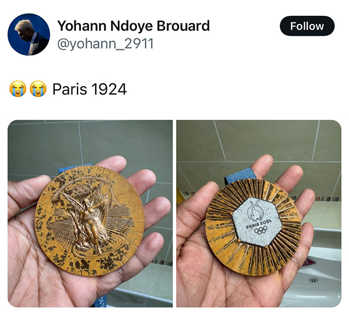 Athlete holding a Paris Olympic medal in hand, featuring intricate designs on the front and back. Athlete holding a Paris Olympic medal in hand, featuring intricate designs on the front and back.