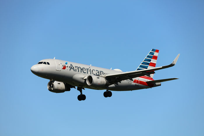 American Airlines plane in flight against a clear blue sky. American Airlines plane in flight against a clear blue sky.