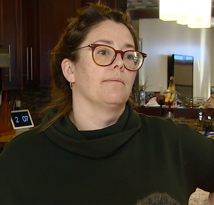 Woman in glasses discussing a family-held-hostage incident at a Cancun resort, wearing a dark sweater indoors. Woman in glasses discussing a family-held-hostage incident at a Cancun resort, wearing a dark sweater indoors.