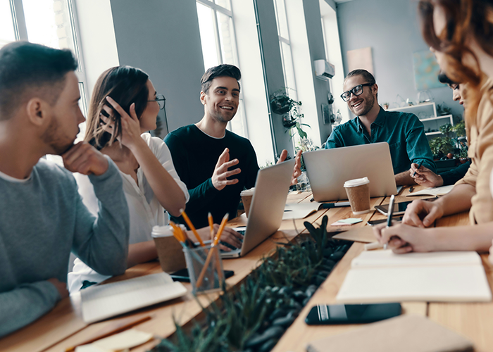 People in a meeting, discussing business topics with laptops and notebooks on the table. People in a meeting, discussing business topics with laptops and notebooks on the table.