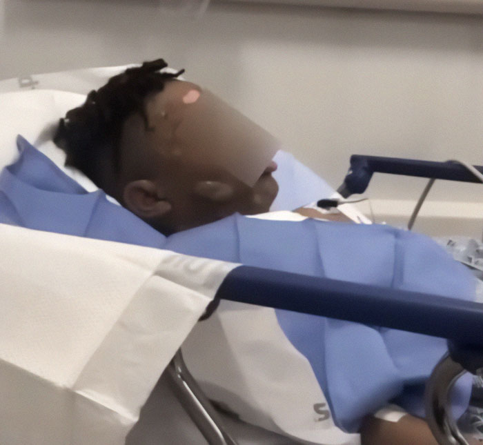 A 12-year-old boy in a hospital bed after a hot water prank at a sleepover, covered with a blue blanket. A 12-year-old boy in a hospital bed after a hot water prank at a sleepover, covered with a blue blanket.