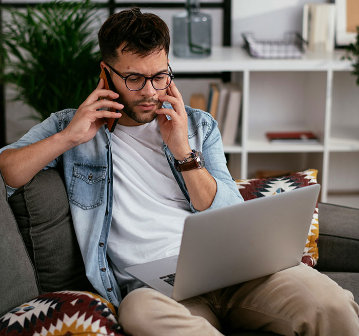 Man on phone and laptop, planning every day revenge due to unpaid client work. Man on phone and laptop, planning every day revenge due to unpaid client work.
