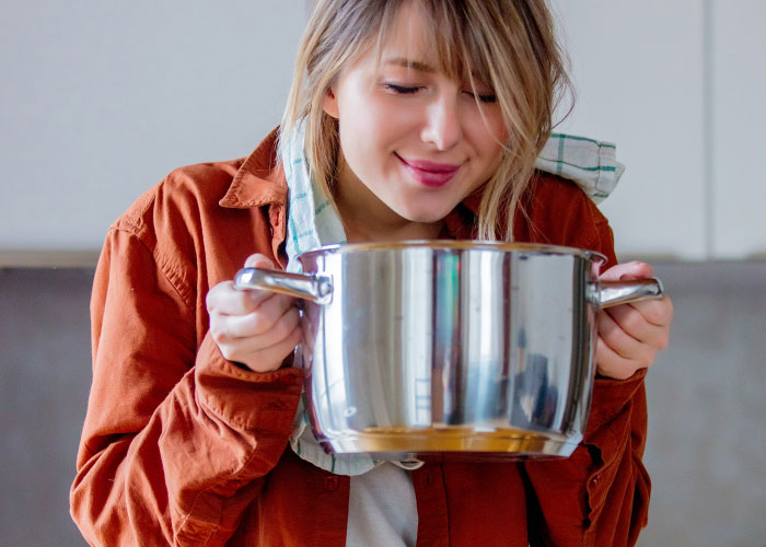 Person in a kitchen holding a pot, possibly representing company potluck disappointment. Person in a kitchen holding a pot, possibly representing company potluck disappointment.