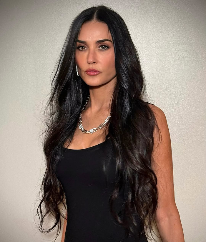 Demi Moore in a black dress posing against a plain background. Demi Moore in a black dress posing against a plain background.