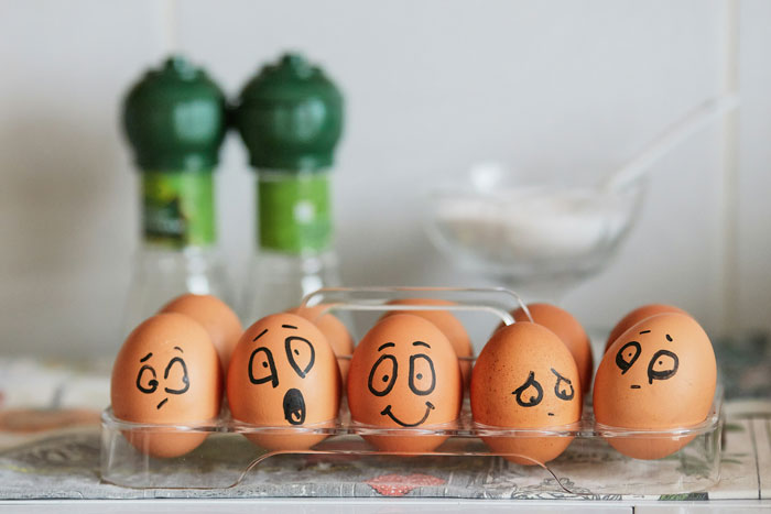 Carton of eggs with cartoon faces, reflecting humor about record-high egg prices in the US. Carton of eggs with cartoon faces, reflecting humor about record-high egg prices in the US.