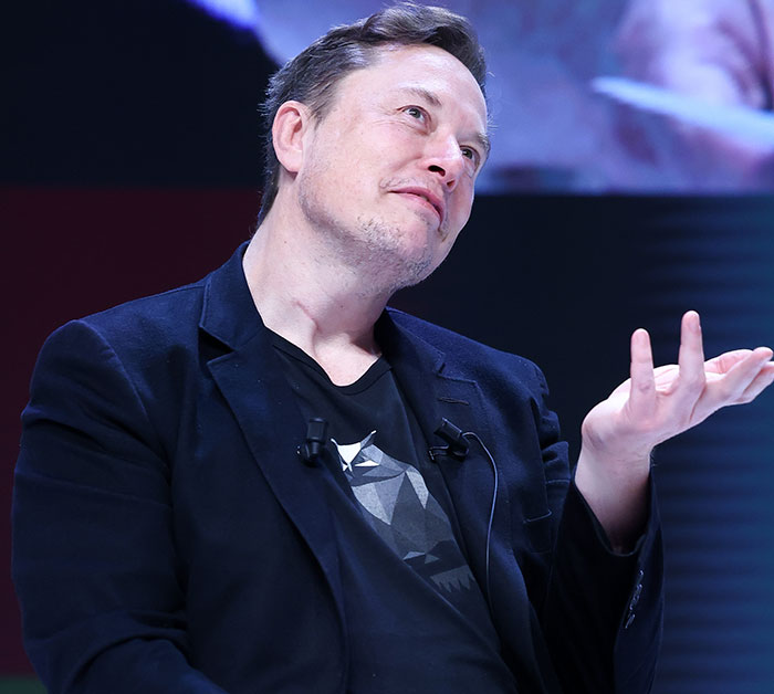 Man in a black blazer shrugging with a thoughtful expression, emphasizing wealth doesn't equate to expertise. Man in a black blazer shrugging with a thoughtful expression, emphasizing wealth doesn't equate to expertise.