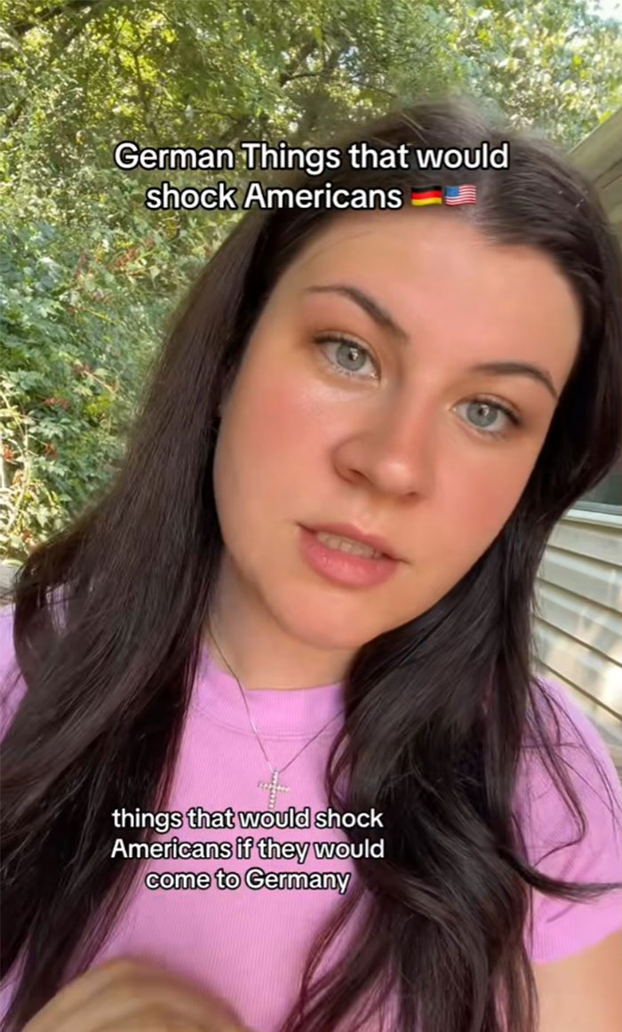 German woman in a pink shirt sharing cultural insights in a garden setting. German woman in a pink shirt sharing cultural insights in a garden setting.