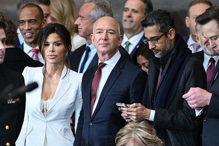 Lauren Sanchez in white attire alongside Jeff Bezos at an event. Lauren Sanchez in white attire alongside Jeff Bezos at an event.