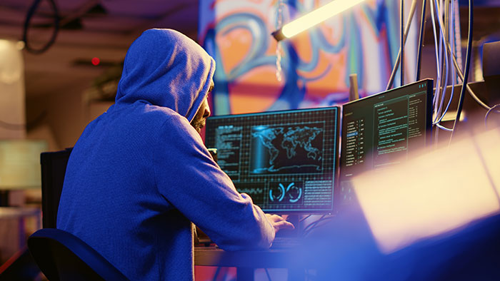 Person in a blue hoodie at a computer, possibly involved in background check related to social security numbers. Person in a blue hoodie at a computer, possibly involved in background check related to social security numbers.