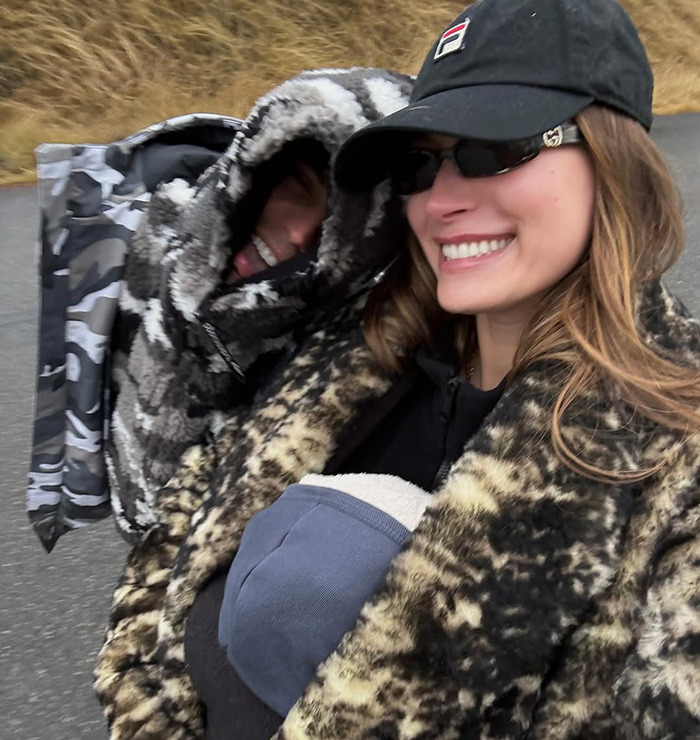 Justin Bieber and Hailey Bieber bundled in camouflage and leopard print coats, smiling outdoors. Justin Bieber and Hailey Bieber bundled in camouflage and leopard print coats, smiling outdoors.