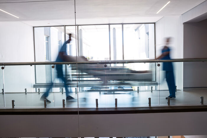 Hospital staff rushing a patient on a gurney in a bright corridor, highlighting Prospect Medical's financial struggles. Hospital staff rushing a patient on a gurney in a bright corridor, highlighting Prospect Medical's financial struggles.
