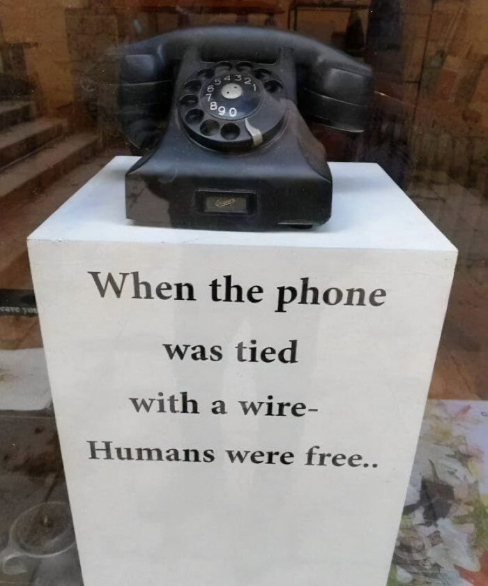 Vintage rotary phone on a pedestal with text about freedom, reflecting humans-of-capitalism-pictures theme.