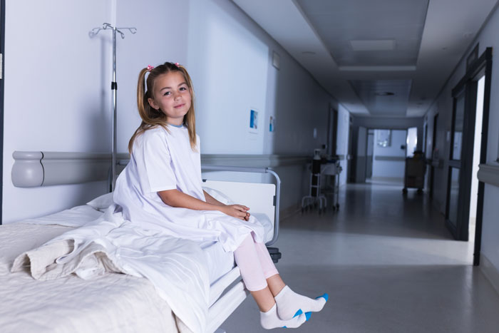 Young girl in a hospital corridor, highlighting daughter responsibility. Young girl in a hospital corridor, highlighting daughter responsibility.