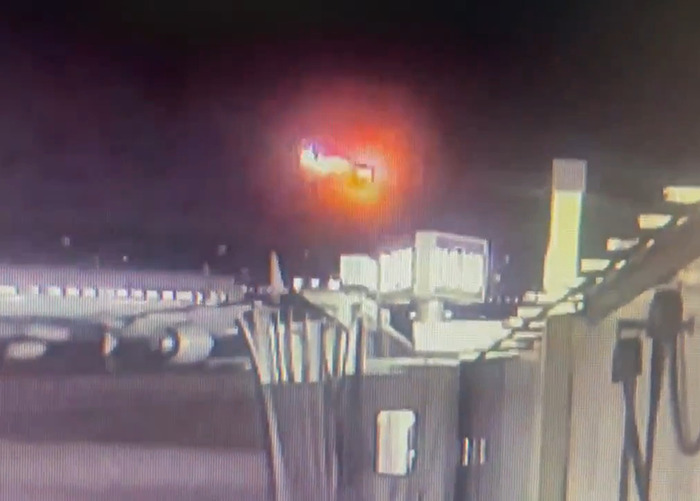 Blurry image of DC American Airlines plane crash at night, with bright fireball in the sky. Blurry image of DC American Airlines plane crash at night, with bright fireball in the sky.