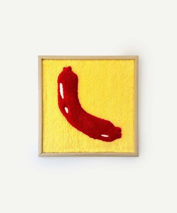 Tufted artwork featuring a red abstract shape on a yellow background by Cléa Delogu.