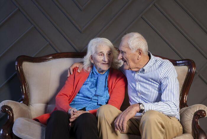 Elderly in-laws sitting on a sofa, engaged in a warm conversation, wearing casual clothes. Elderly in-laws sitting on a sofa, engaged in a warm conversation, wearing casual clothes.