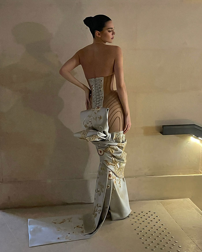 Fashion model in a stylish dress at Paris Fashion Week, showcasing a unique couture design. Fashion model in a stylish dress at Paris Fashion Week, showcasing a unique couture design.