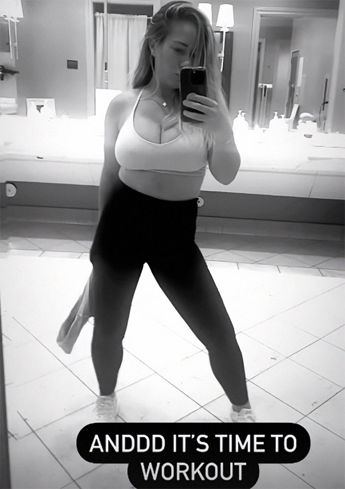 Former model in workout attire taking a mirror selfie in a tiled bathroom with a motivational caption. Former model in workout attire taking a mirror selfie in a tiled bathroom with a motivational caption.