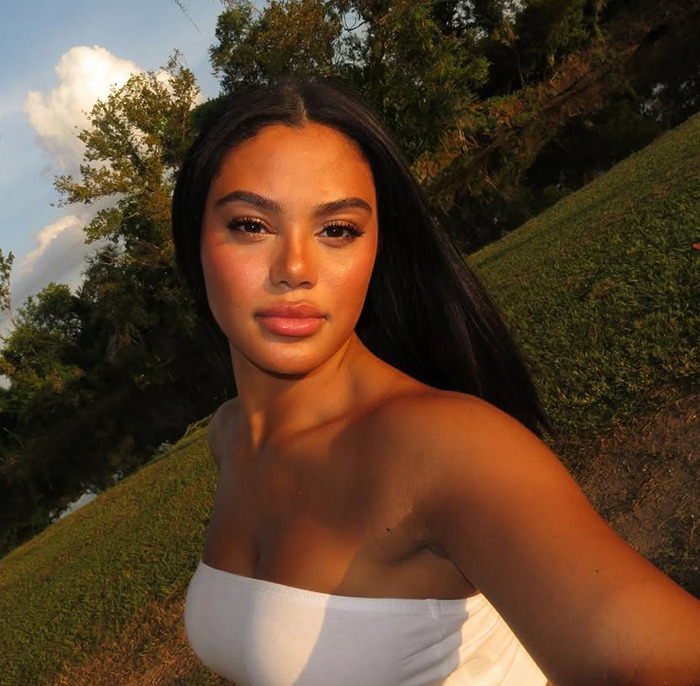 Kaya Odom outdoors with glowing skin surrounded by trees and a pond. Kaya Odom outdoors with glowing skin surrounded by trees and a pond.