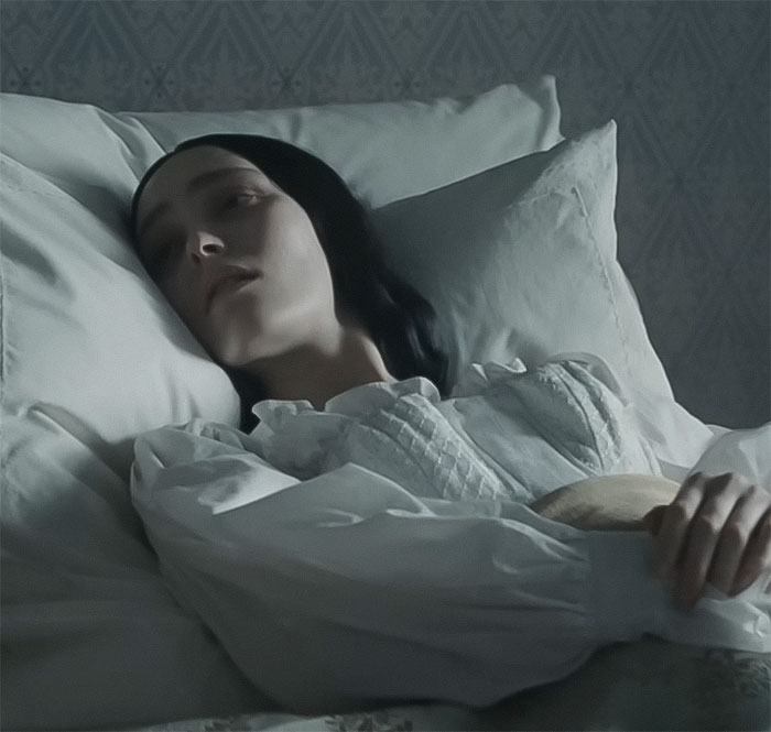 Young woman in a period costume lying in bed, emulating a scene from Nosferatu audition video. Young woman in a period costume lying in bed, emulating a scene from Nosferatu audition video.