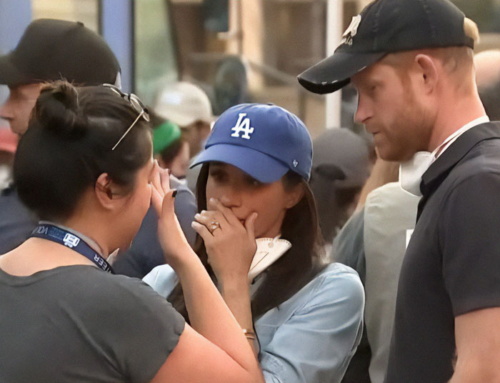 Prince Harry and Meghan Markle console someone wearing a LA hat during a visit to LA fire victims. Prince Harry and Meghan Markle console someone wearing a LA hat during a visit to LA fire victims.