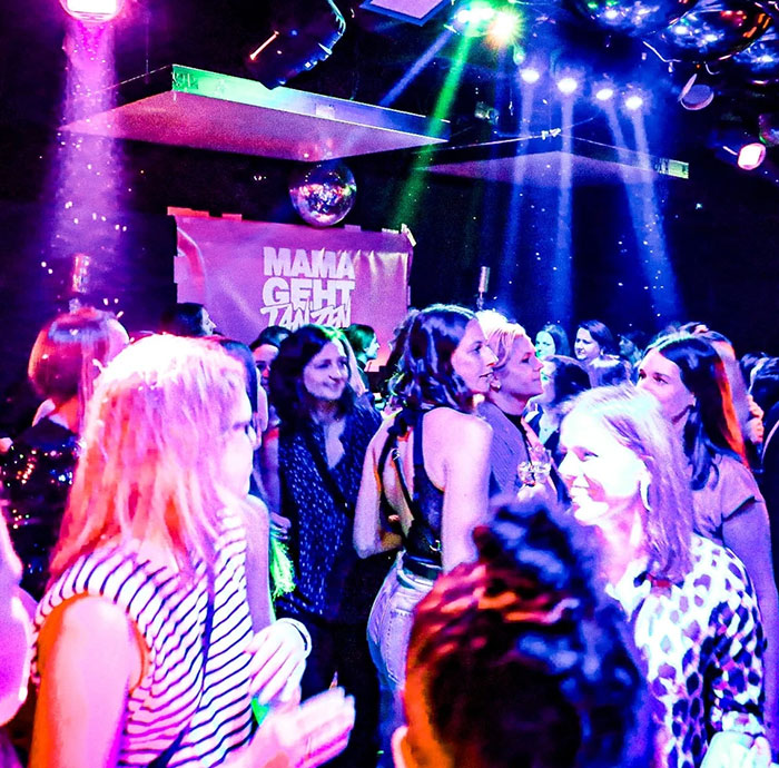 Moms enjoying a vibrant nightclub party, redefining nightlife after kids are asleep, with colorful lights and lively atmosphere. Moms enjoying a vibrant nightclub party, redefining nightlife after kids are asleep, with colorful lights and lively atmosphere.