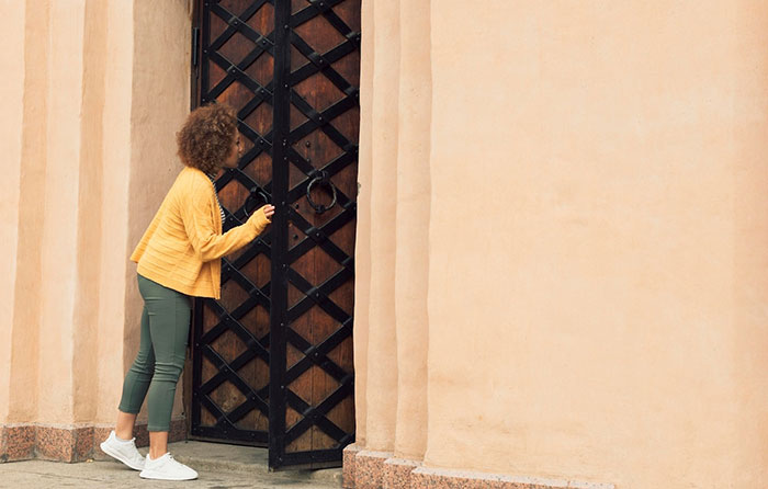 Woman in a yellow jacket at a large gate, symbolizing unexpected family visits and inheritance issues. Woman in a yellow jacket at a large gate, symbolizing unexpected family visits and inheritance issues.