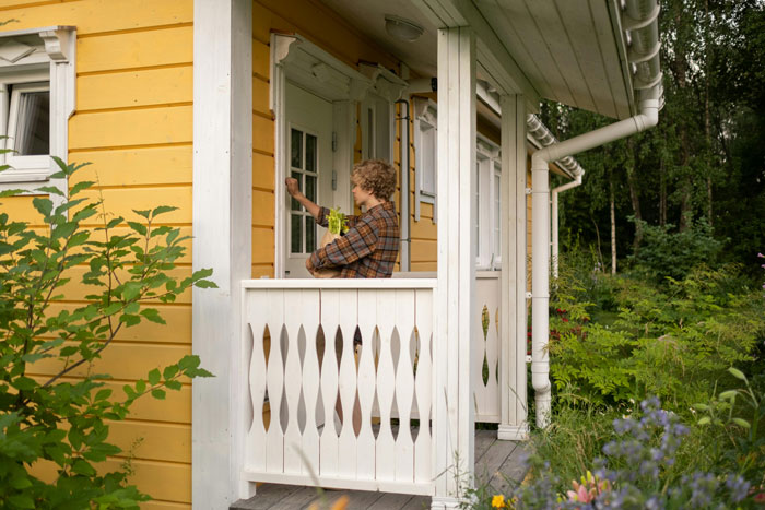 Person knocking on a neighbor's door, surrounded by greenery, in a cozy yard setting. Person knocking on a neighbor's door, surrounded by greenery, in a cozy yard setting.