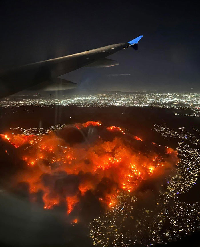 Aerial view of La Palisades fire at night, city lights in the background, sparks conspiracy theories. Aerial view of La Palisades fire at night, city lights in the background, sparks conspiracy theories.