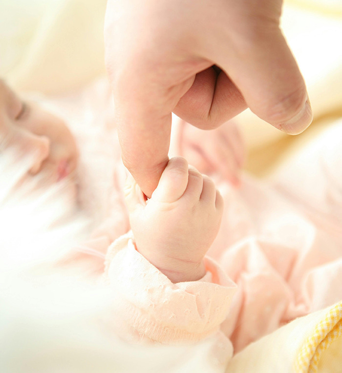 Baby holding an adult’s finger, representing Generation Beta connection. Baby holding an adult’s finger, representing Generation Beta connection.