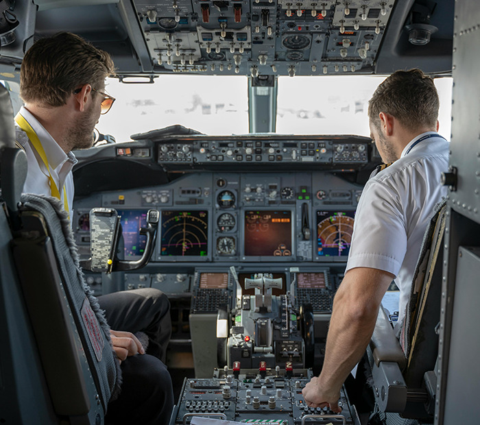 Pilots in a cockpit discussing practices at civilian airports. Pilots in a cockpit discussing practices at civilian airports.