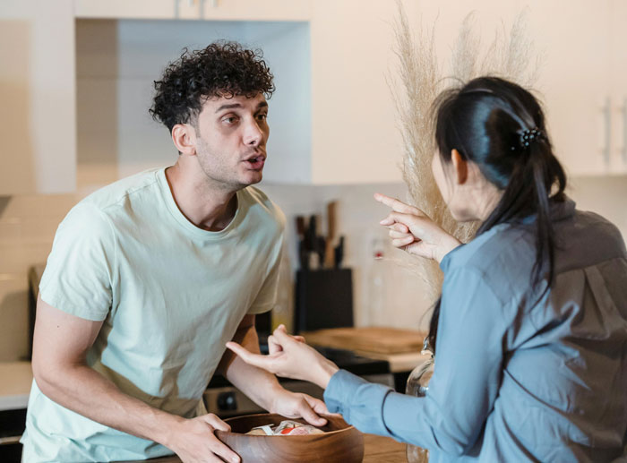 Couple having a discussion in a kitchen about posting political content, highlighting themes of career and censorship. Couple having a discussion in a kitchen about posting political content, highlighting themes of career and censorship.