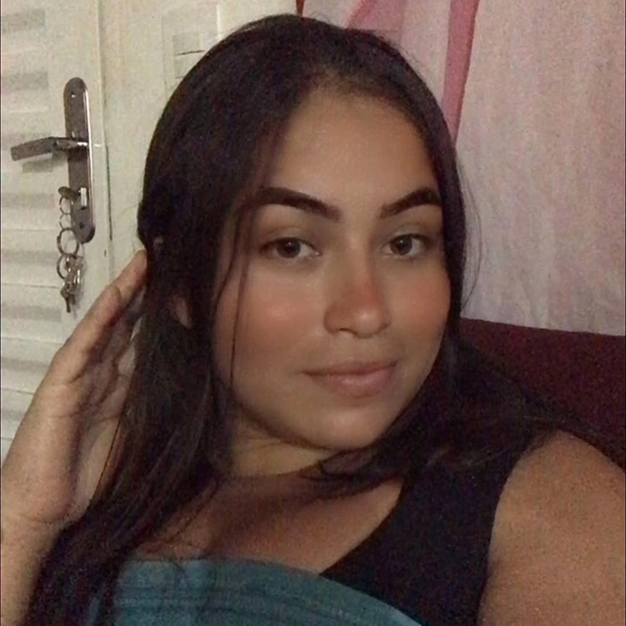 Joyce Sousa Araújo at home, smiling and holding her hair, related to life support debate. Joyce Sousa Araújo at home, smiling and holding her hair, related to life support debate.